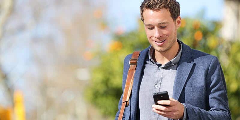 Mand går udenfor og får en besked fra NaviPartners SMS-afsenderen